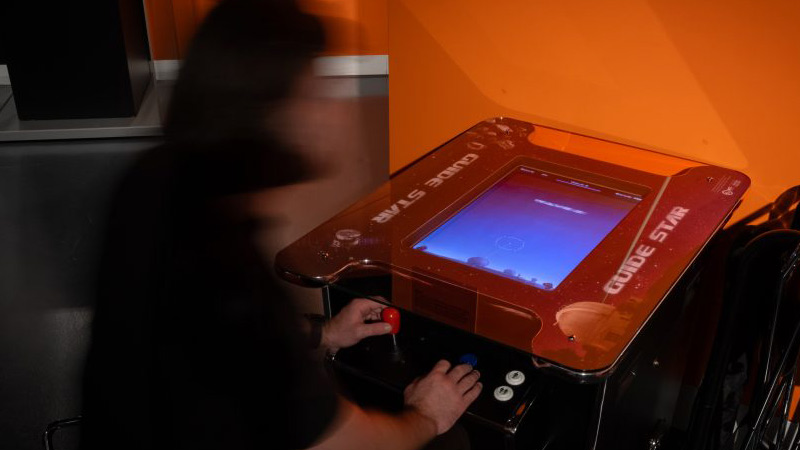 Photo of a child playing the arcade game Guide Star